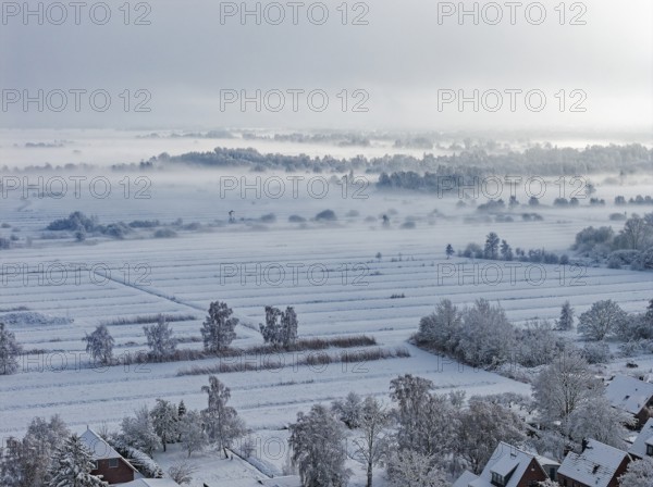 The onset of winter with snow and ground fog in Hamburg's Kirchwerder Wiesen Nature Reserve in the Vier- and Marschlanden. aerial view. Kirchwerder, Hamburg, Germany
