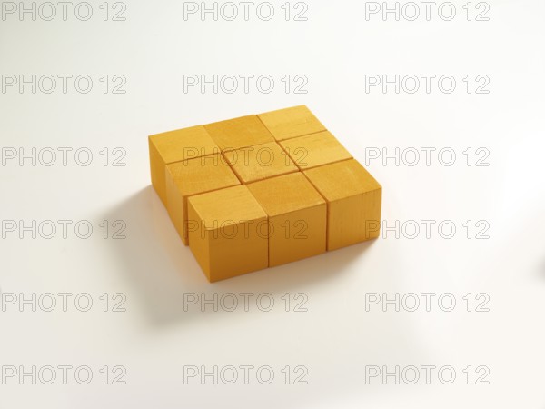 9 yellow wooden cubes against a white background