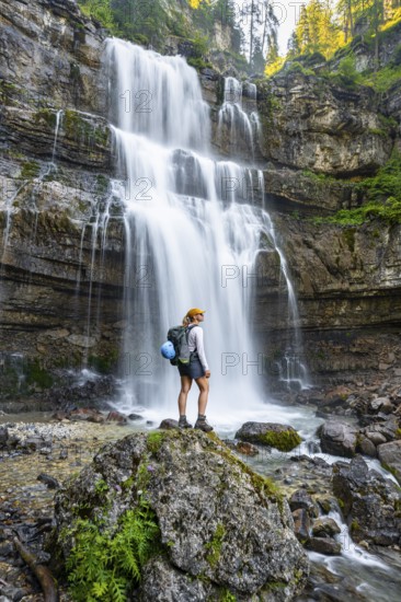 Young woman in front of Cascata di Mezzo waterfall, long exposure, Vallesinella, Brenta, Trentino, Italy