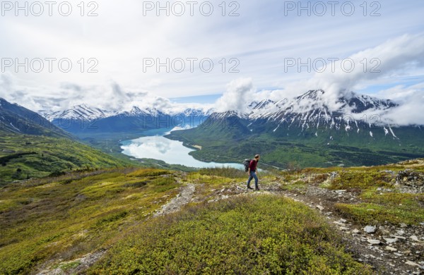 Climbers on a hiking trail, Slaughter Ridge Trail, view of snowy mountains and turquoise lake Kenai Lake, Cooper Landing, Kenai Peninsula, Alaska, USA