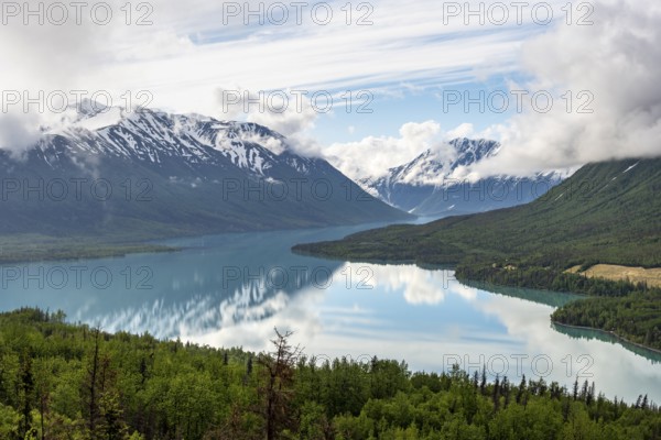 View of snowy mountains in spring and turquoise Kenai Lake with reflection, Slaughter Ridge Trail, Cooper Landing, Kenai Peninsula, Alaska, USA