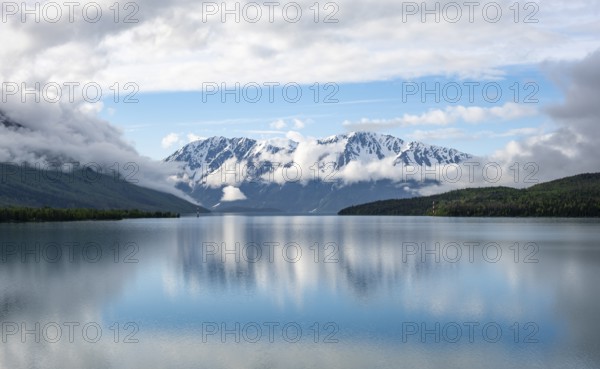 Snowy mountains in spring are reflected in turquoise blue Kenai Lake, Cooper Landing, Kenai Peninsula, Alaska, USA
