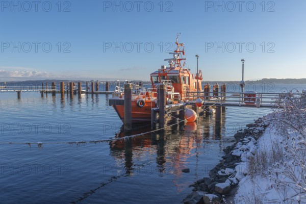 Kiel-Holtenau pilot station in front of the Kiel Canal, pilot boat, channel guidance, shipping, safety, dolphins, pier, Kiel Fjord, Baltic Sea, on the horizon east shore with Heikendorf, calm sea, winter, snowfall, sunshine, blue sky, Kiel, Germany