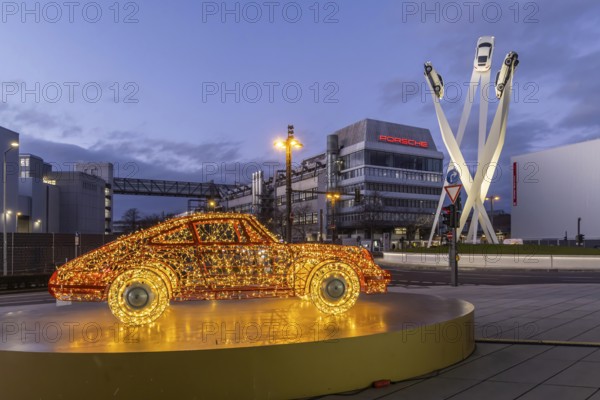 Highlights on Porscheplatz in Zuffenhausen. In front of the Porsche Museum and the car manufacturer's headquarters, a 911 sports car shines in Christmassy splendor. Stuttgart, Baden-Württemberg, Germany