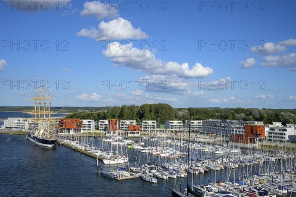 Harbour view with the legendary four-masted PASSAT barque and many boats in front of modern buildings under blue skies, Travemünde, Lübeck, Schleswig-Holstein, Germany
