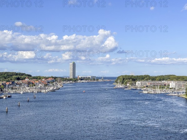 View over the Trave towards the mouth in the underground, the church of Travemünde and the Atlantic Hotel, with clouds and birds, Travemünde, Lübeck, Schleswig-Holstein, Germany