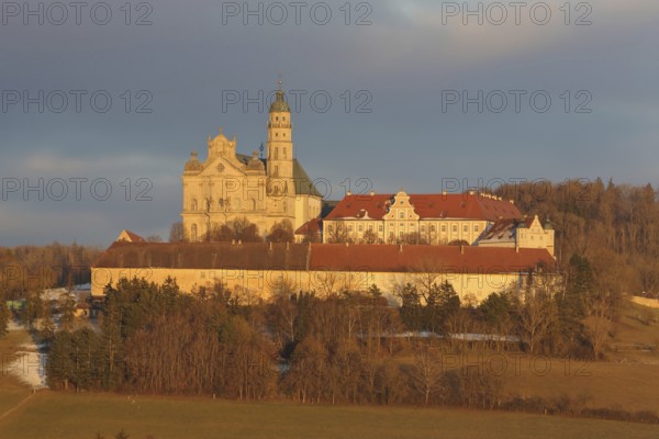 Benedictine monastery with late baroque monastery church, lighting atmosphere, winter, Neresheim, Härtsfeld, Swabian Jura, Baden-Württemberg, Germany