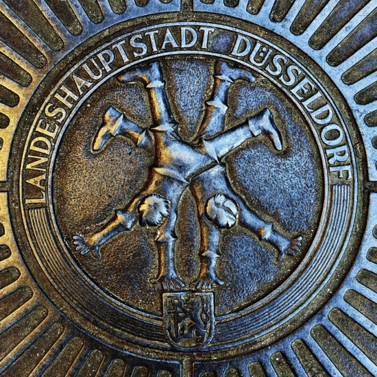 Manhole cover with classic depiction of the racket, landmark of the state capital Düsseldorf, North Rhine-Westphalia, Germany