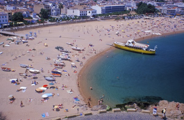 Houses, people, sightseeing boat on Tossa de Mar beach, Costa Brava, Spain, June 1999, vintage, retro, old, historic