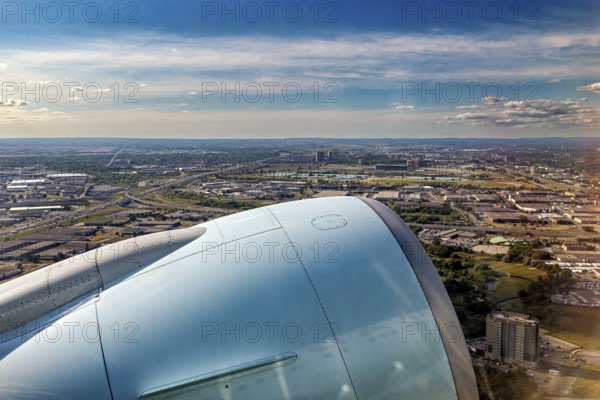 An impressive view of the city and the blue sky opens up from the aircraft turbine, a view from an airplane of the suburbs of Toronto in Canada