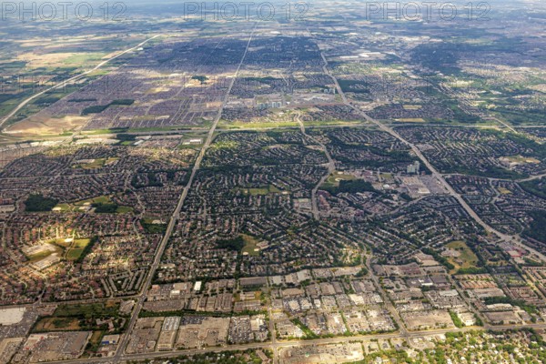 Vast urban areas with a distinctive striped pattern under a blue sky, view from an airplane of the suburbs of Toronto in Canada