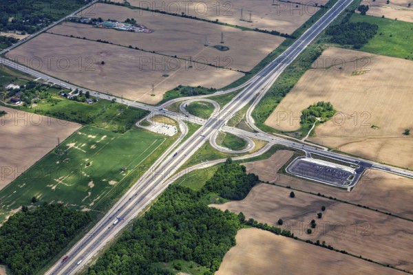 A large road junction surrounded by fields and green spaces, visible from the air, view from an airplane of the suburbs of Toronto in Canada