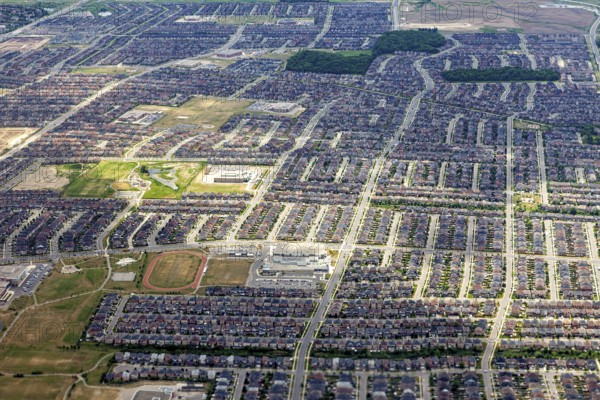 A densely built residential area with a clearly recognizable street pattern seen from the air, view from an airplane of the suburbs of Toronto in Canada