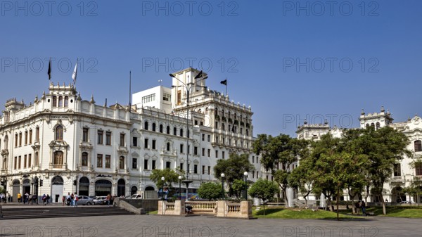 Impressive colonial building on an open square with trees and clear sky, Downtown Lima in Peru