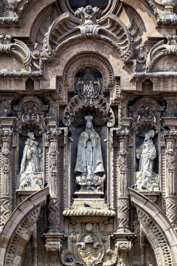 Ornate baroque façade with several statues and decorations, reliefs on the Basilica of St. Francis in Lima in Peru