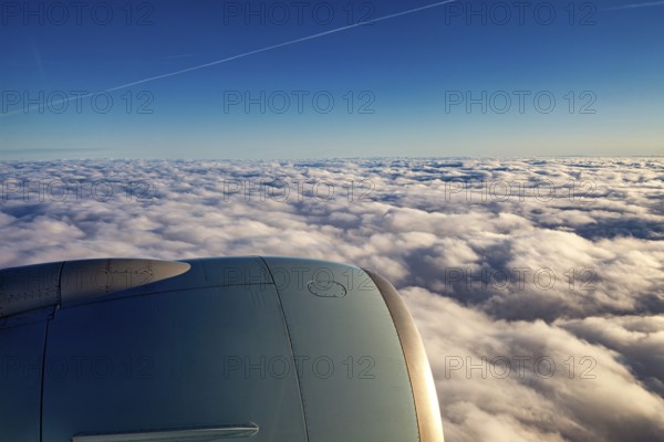 View of aircraft engine above white clouds under blue sky, On an airplane above the clouds