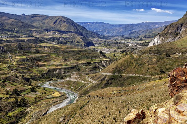 River valley with terraces and mountains under sweeping skies, the landscape of the Colca Canyon in the Andes of Peru