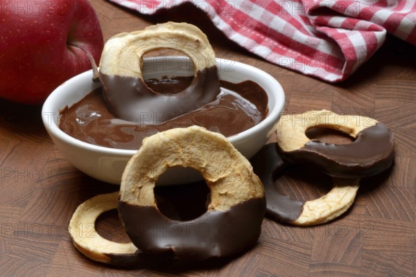 Apple rings, coated with chocolate, chocolate glaze in bowl