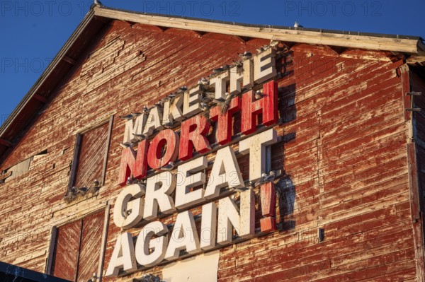 Red fishing building with the inscription Make the North great again at Vardö harbour, Vardø, Finnmark, Norway