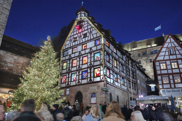 Christmassy illuminated square with the historic Pilate House with advent calendar, in the evening lighting, the Kaiserburg in the back, Beim Tiergärtnertor, Nuremberg, Middle Franconia, Bavaria, Germany