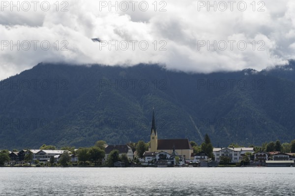 View from the Point peninsula of the district of Egern, parish church of St. Lawrence, behind Wallberg with clouds, Tegernsee, Rottach-Egern, Upper Bavaria, Bavaria, Germany