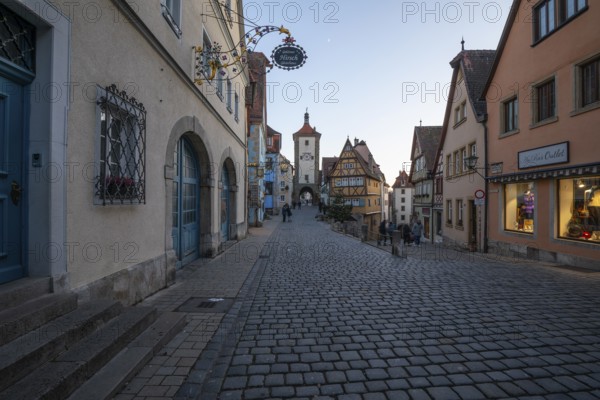 December 25, 2025: Christmastime at Plönlein — Rothenburg ob der Tauber, Bavaria, Germany. Festive Christmas tree and city lights at blue hour with moon in the sky