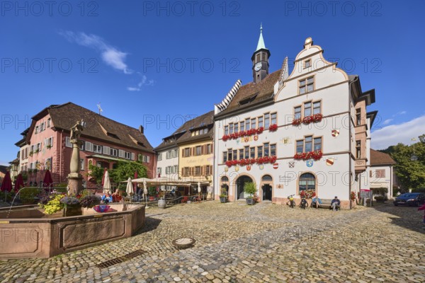 Historic town hall, market fountain, general architecture, historic buildings, houses, cobblestone square, outdoor area of a restaurant, café town hall café, trees, blue sky, cumulus clouds, intersection of main street with Kirchstraße, Staufen im Breisgau, Black Forest, Breisgau-Hochschwarzwald district, Baden-Württemberg, Germany