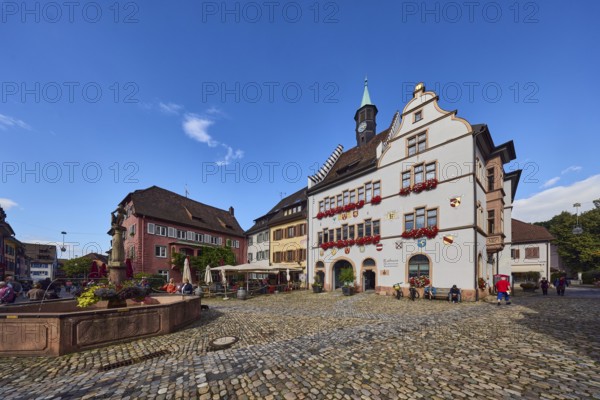 Historic town hall, market fountain, general architecture, houses, cobblestone square, outdoor area of a restaurant, blue sky, cumulus clouds, intersection of main street with Kirchstraße, Staufen im Breisgau, Black Forest, Breisgau-Hochschwarzwald district, Baden-Württemberg, Germany