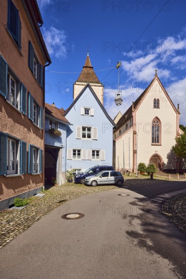St. Martin parish church, church tower, houses, historic residential buildings, apartment buildings, street, curve, cars, trees, blue sky, cumulus clouds, Kirchstraße, Staufen im Breisgau, Black Forest, Breisgau-Hochschwarzwald district, Baden-Württemberg, Germany