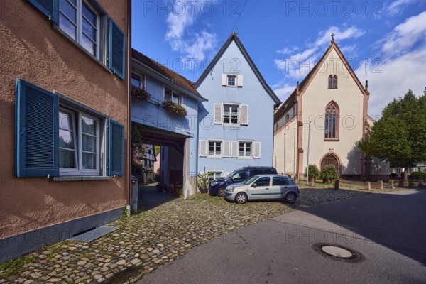 St. Martin parish church, houses, historic residential buildings, multi-family houses, road, curve, cars, trees, blue sky, cumulus clouds, Kirchstraße, Staufen im Breisgau, Black Forest, Breisgau-Hochschwarzwald district, Baden-Württemberg, Germany