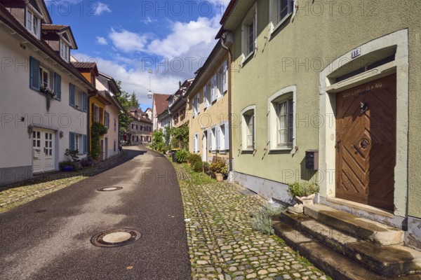 Residential buildings, apartment buildings, houses, general architecture, entrance, staircase, façade with windows, flower pots, wet road, blue sky, cumulus clouds, alleyway St.-Johannesgasse, Staufen im Breisgau, Black Forest, Breisgau-Hochschwarzwald district, Baden-Württemberg, Germany