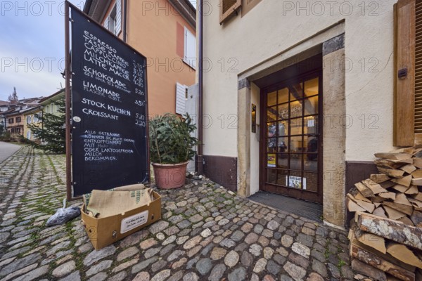 Café and coffee roastery Coffee and more, general architecture, houses, residential and commercial buildings, apartment buildings, entrance, façade, door, display, cobblestone walkway, frog-eye view, cloudy, diffused light, alleyway St.-Johannesgasse, Staufen im Breisgau, Black Forest, Breisgau-Hochschwarzwald district, Baden-Württemberg, Germany