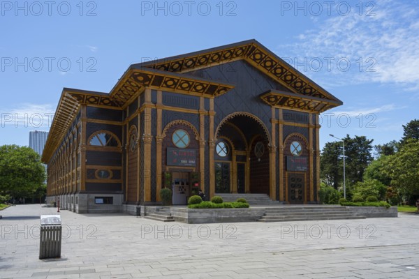 In sunlight, an artfully designed wooden building with well-kept surroundings and clear skies, Summer Theatre, Batumi, Black Sea, Ajara region, Adjara, Autonomous Republic, Georgia