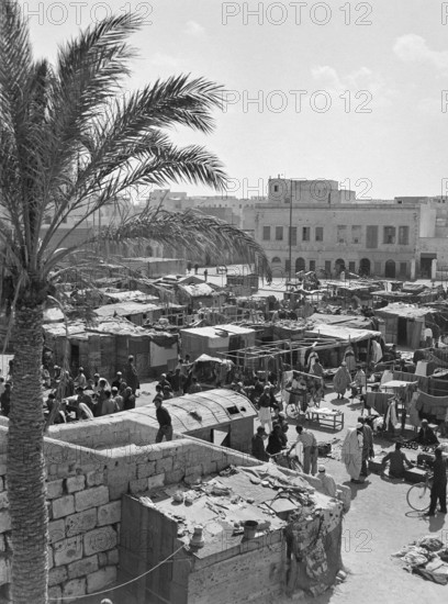 Market stalls and people in market souk in media old town area of Tripoli, Libya, North Africa 1956