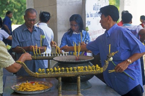 Believers light candles in front of the temple with the Buddha statue Phra Mongkhonbophit, Ayutthaya, Thailand, December 2002, vintage, retro, old, historic