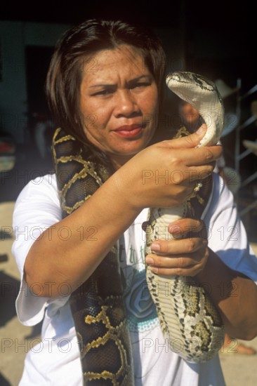 A woman presents a python in Damnoen Saduak near Bangkok, Thailand, December 2002, vintage, retro, old, historic