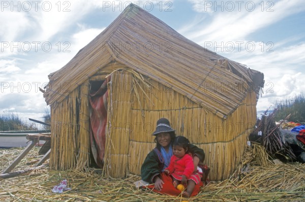 Children sitting in front of a reed hut on a floating Uro island in Lake Titcaca, Peru, South America, September 1997, vintage, retro, old, historic