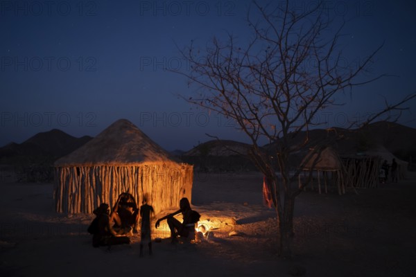 Himba at the campfire in the evening, night view, Himba huts, traditional Himba village in the savanna, Kaokoveld, Kunene, Namibia