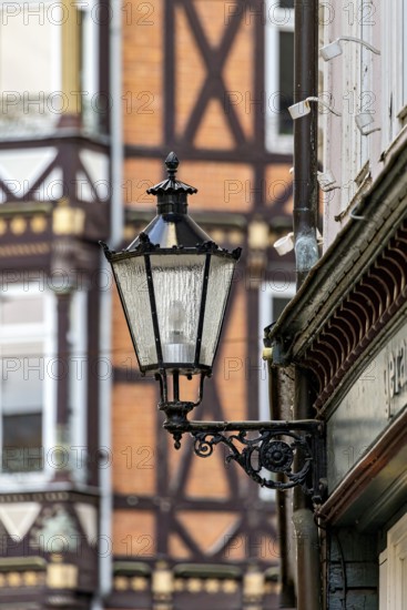 Nostalgic lantern in front of a half-timbered house with distinctive architectural patterns and windows, The historic street lamps of Marburg an der Lahn in Hesse
