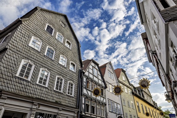 View of half-timbered houses under a vivid blue sky with decorative sun ornaments, The historic old town of Marburg an der Lahn in Hesse