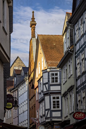 Picturesque old town street with half-timbered houses and business signs in sunlight, The historic old town of Marburg an der Lahn in Hesse