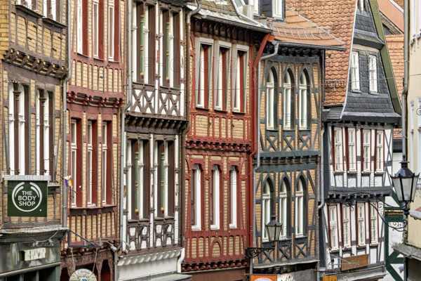 Detailed, colorful half-timbered facades in a cramped old town alleyway, The historic old town of Marburg an der Lahn in Hesse