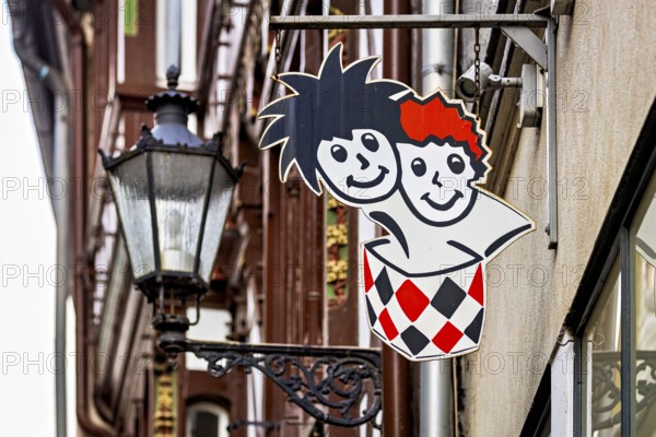 Lantern next to a colorful advertising sign in urban areas with traditional building facades, The historic street lamps of Marburg an der Lahn in Hesse