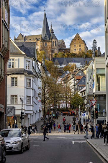 City life in Marburg with a mix of modern and historic buildings and a church in the background, The Landgrave Castle of Marburg in Hesse