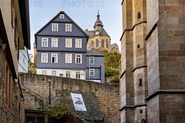 Church over historic city walls in warm evening light, The historic city center of Marburg in Hesse