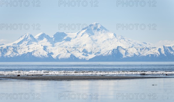 Beach at Anchor Point, Cook Inlet, glaciated mountain peaks of the Aleutian Range with Mount Iliamna summit, Anchor River State Recreation Area, Alaska, USA