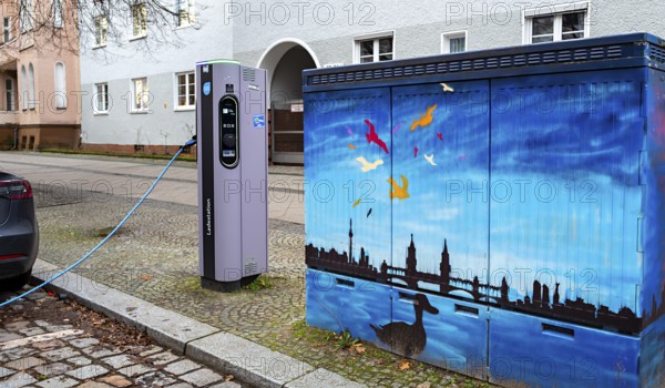 Electric charging station next to a blue-painted distribution box on public roads, Berlin, Germany