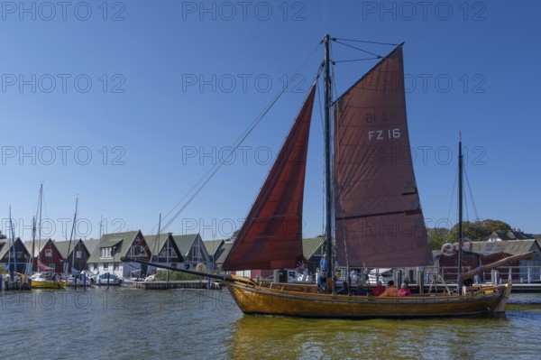 Zeesboot, former historic fishing boat, leaves the port of Ahrenshoop, blue sky, Darß, Mecklenburg-Western Pomerania, Germany