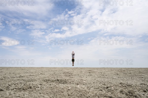 Symbolic picture, abstract, man jumping on the Etosha pan, salt pan, Etosha National Park, Namibia