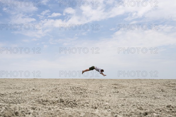 Abstract, man jumping horizontally at the Etosha pan, salt pan, Etosha National Park, Namibia